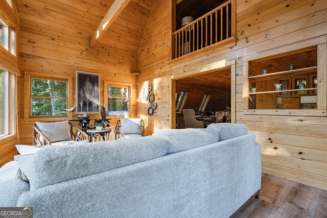 dining area with wood walls, wooden ceiling, hardwood / wood-style flooring, and lofted ceiling with skylight