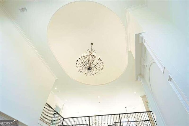 interior details featuring an inviting chandelier and crown molding