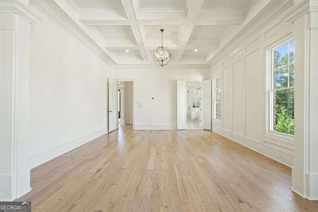 interior space featuring light hardwood / wood-style floors, a notable chandelier, coffered ceiling, beam ceiling, and ornamental molding