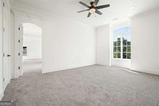 carpeted empty room featuring ornamental molding and ceiling fan