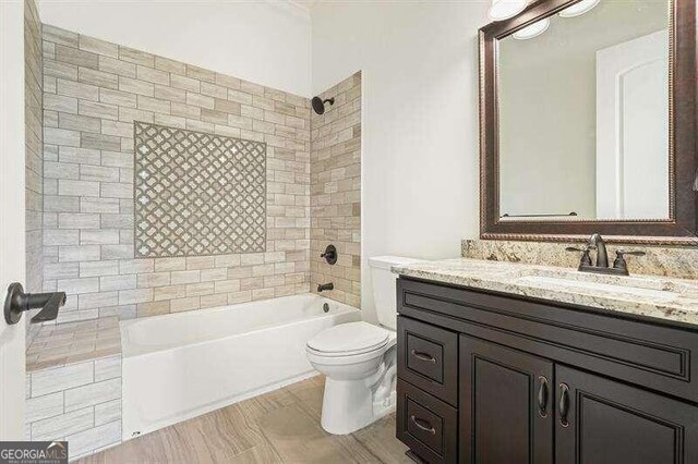 full bathroom featuring tiled shower / bath, toilet, and vanity