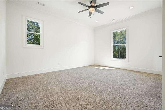 empty room featuring a healthy amount of sunlight, ceiling fan, and light colored carpet