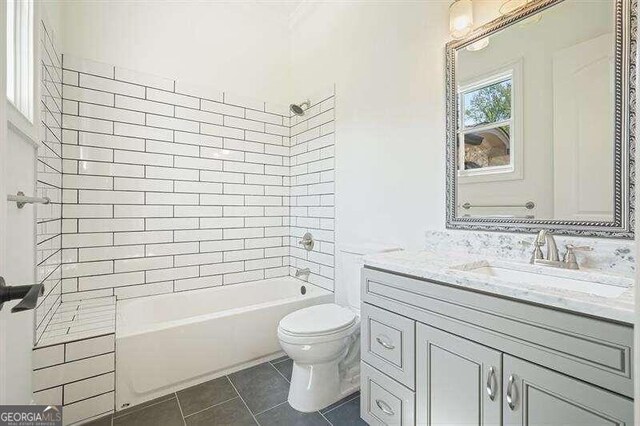 full bathroom with tiled shower / bath, vanity, toilet, and tile patterned flooring