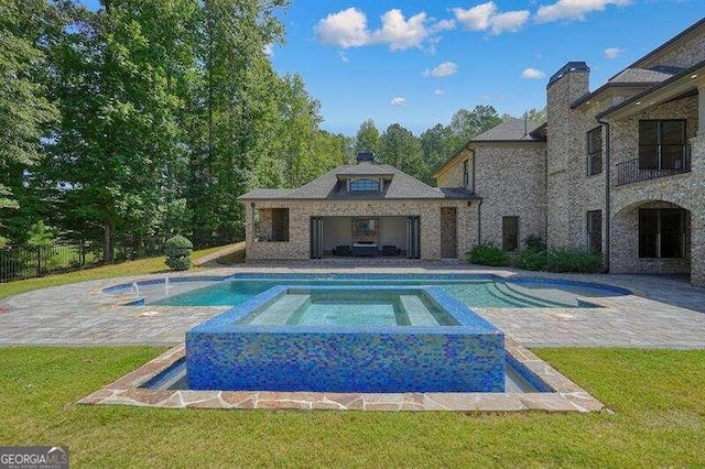 view of pool featuring an in ground hot tub, a lawn, and a patio area