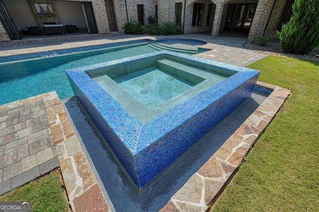 view of swimming pool featuring an in ground hot tub