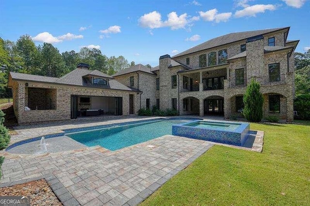 view of swimming pool featuring a lawn, a patio area, and an in ground hot tub