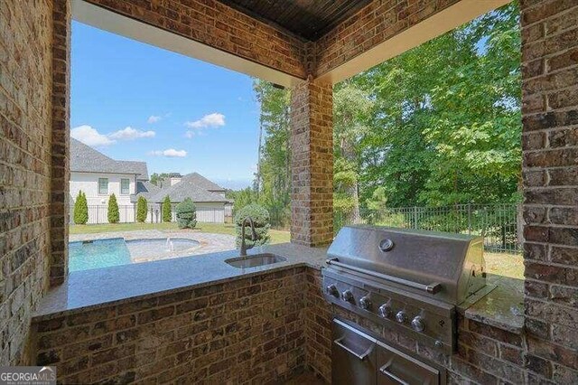 view of patio featuring exterior kitchen, a swimming pool, and area for grilling