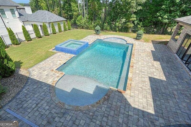 view of swimming pool with a lawn, a patio area, and an in ground hot tub