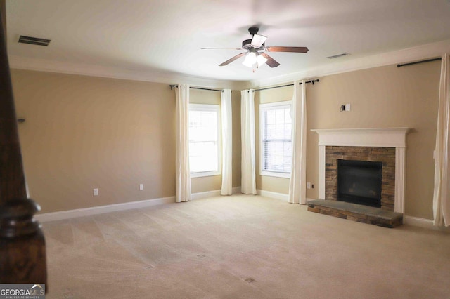 unfurnished living room with light carpet, a fireplace, ceiling fan, and crown molding