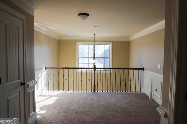 hallway with carpet flooring, ornamental molding, and a notable chandelier