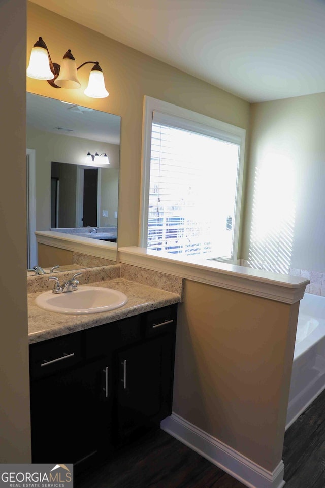 bathroom with vanity, a bathtub, and wood-type flooring