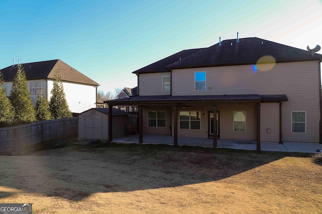 rear view of property featuring a shed and a patio