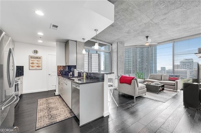 kitchen featuring ceiling fan, decorative light fixtures, decorative backsplash, and dark hardwood / wood-style flooring