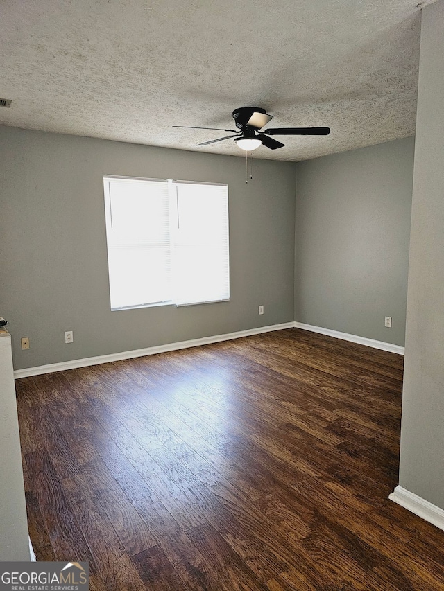 spare room featuring ceiling fan, dark hardwood / wood-style flooring, and a textured ceiling