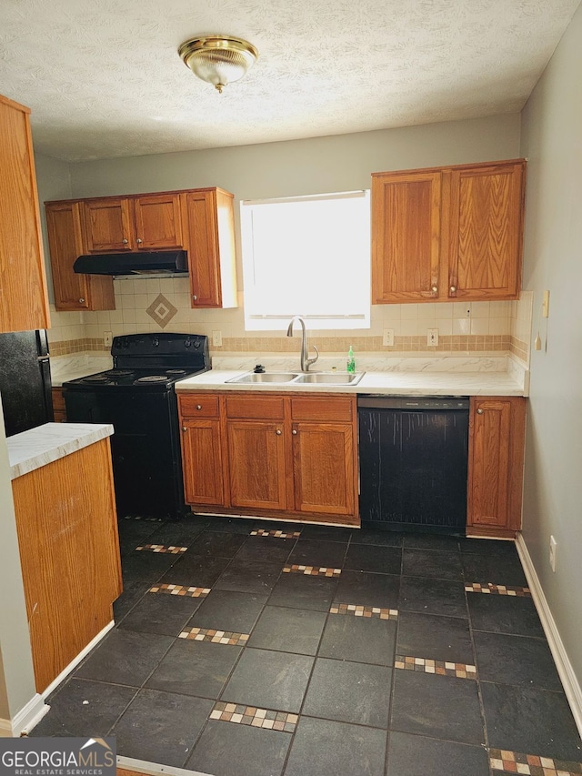 kitchen featuring black appliances, tasteful backsplash, sink, and a textured ceiling