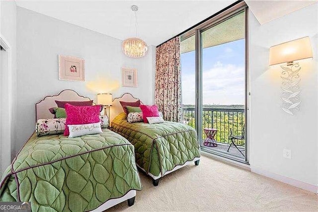 carpeted bedroom with a notable chandelier and access to outside