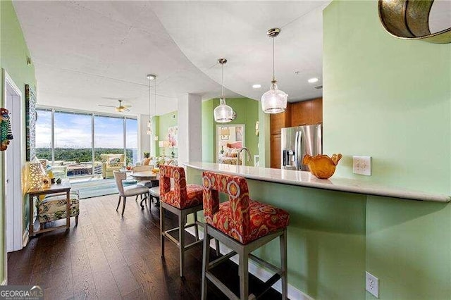 kitchen with stainless steel fridge, kitchen peninsula, and a kitchen bar