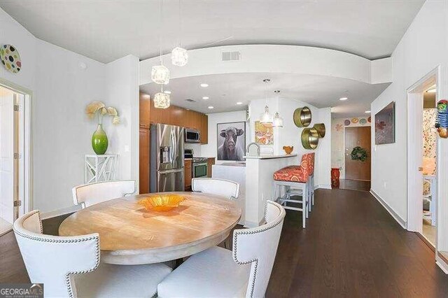 dining area with dark hardwood / wood-style floors and sink