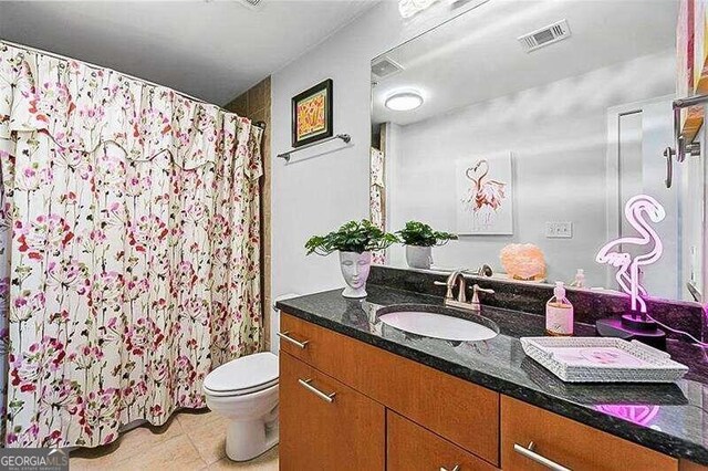 bathroom featuring tile patterned floors, toilet, curtained shower, and vanity