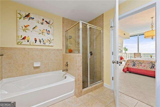 bathroom featuring tile patterned flooring, tile walls, and separate shower and tub