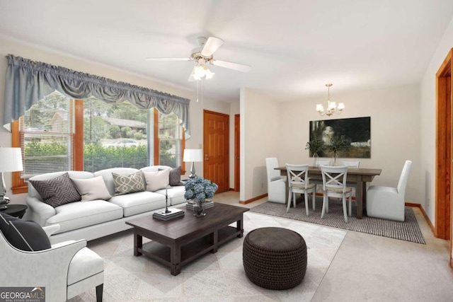 living area featuring baseboards and ceiling fan with notable chandelier