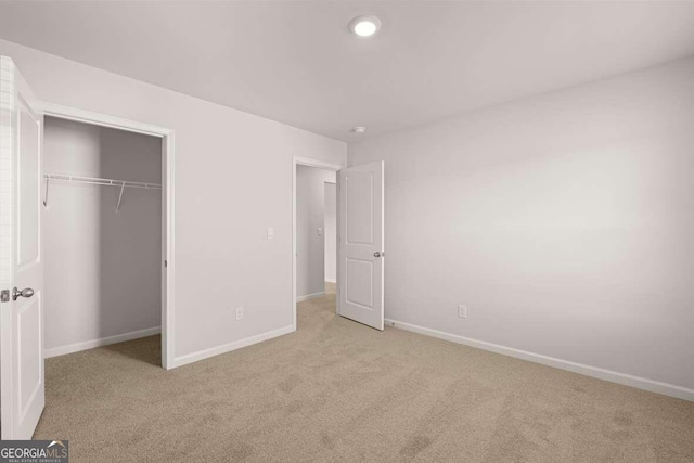 unfurnished bedroom with light carpet and a closet