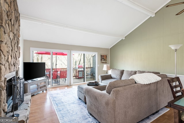 living room with a fireplace, lofted ceiling with beams, and hardwood / wood-style floors