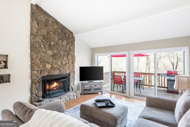 living room featuring a fireplace, beamed ceiling, hardwood / wood-style flooring, and high vaulted ceiling