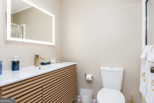 bathroom with toilet, a shower with door, and vanity