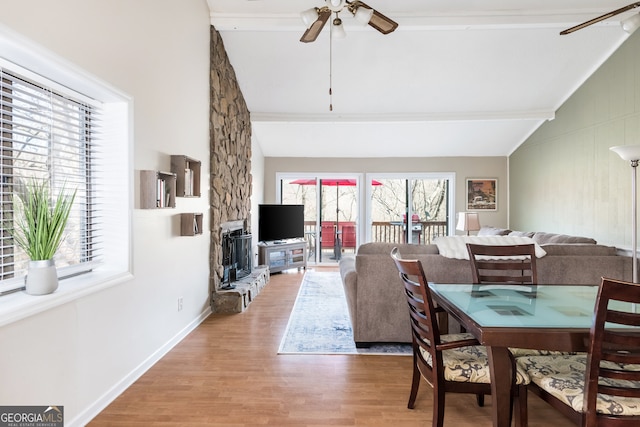 dining room with ceiling fan, hardwood / wood-style floors, and vaulted ceiling with beams