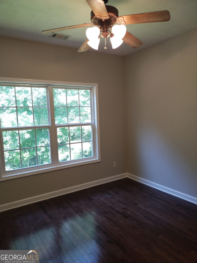 empty room featuring dark wood-type flooring and ceiling fan