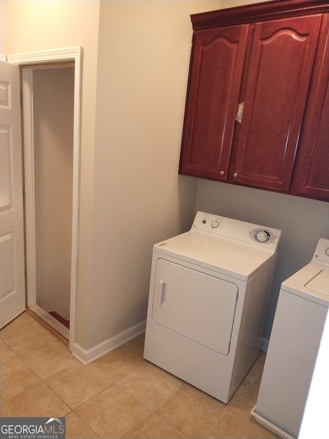 washroom featuring cabinets, washer and dryer, and light tile patterned flooring