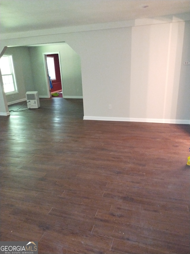 unfurnished room with dark wood-type flooring