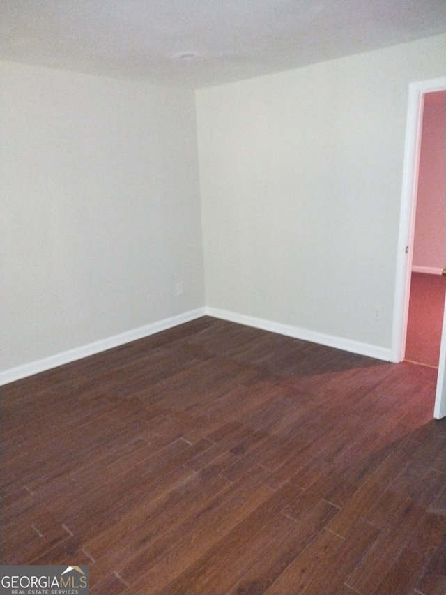 spare room featuring dark wood-type flooring