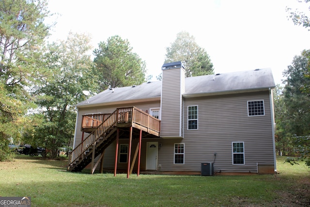 back of property with a deck, a lawn, and central AC