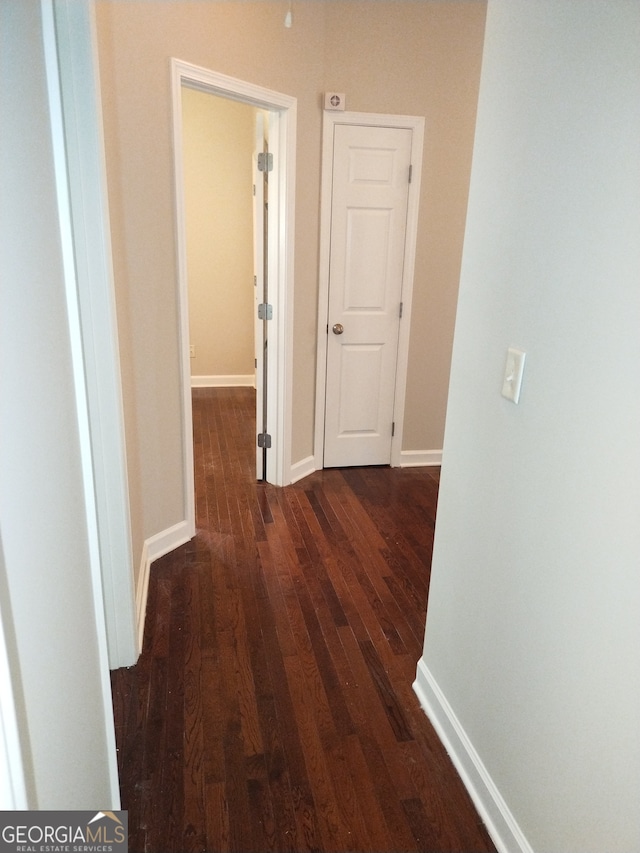 hallway with dark hardwood / wood-style flooring