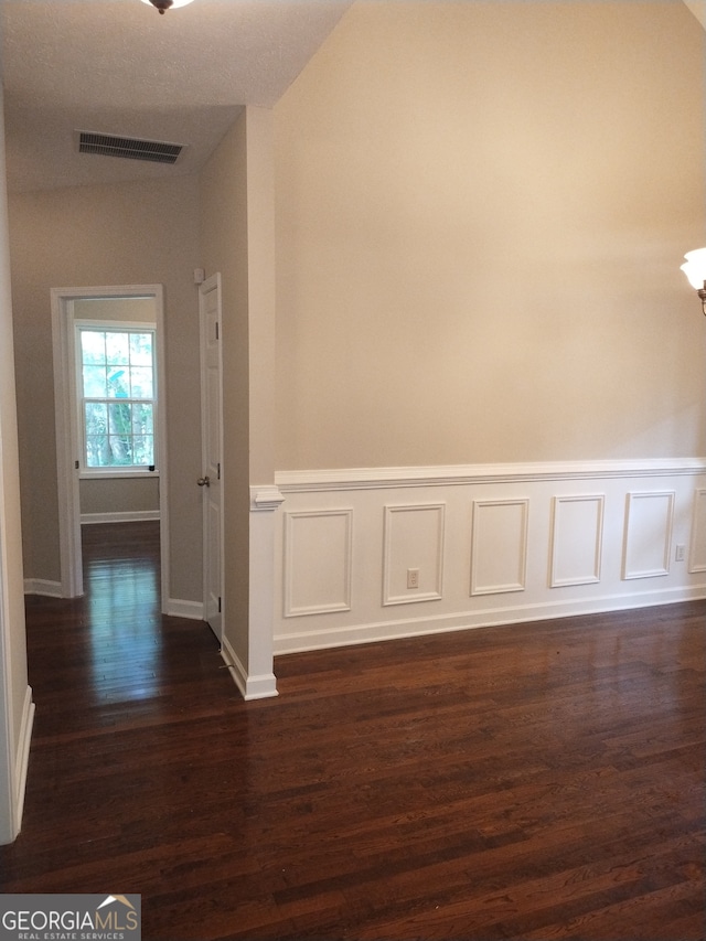 interior space with vaulted ceiling and dark hardwood / wood-style flooring