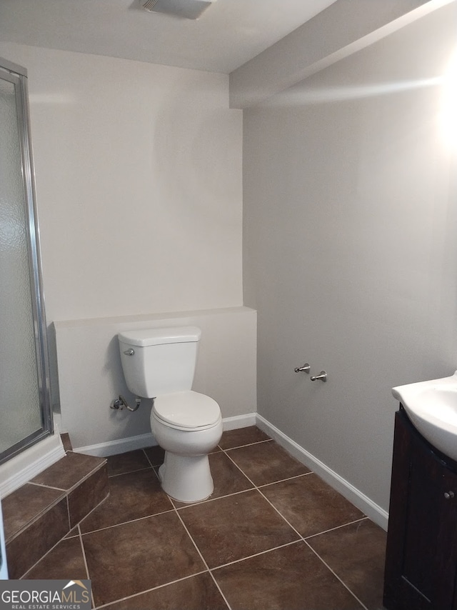 bathroom with vanity, toilet, walk in shower, and tile patterned floors