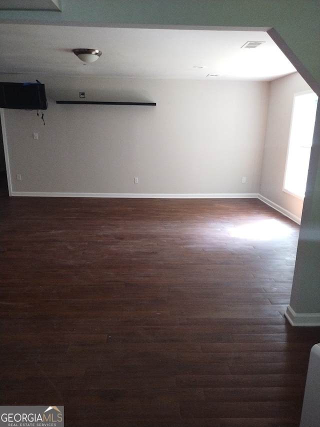 empty room with dark hardwood / wood-style flooring