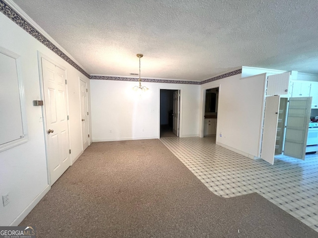 spare room with a notable chandelier and a textured ceiling