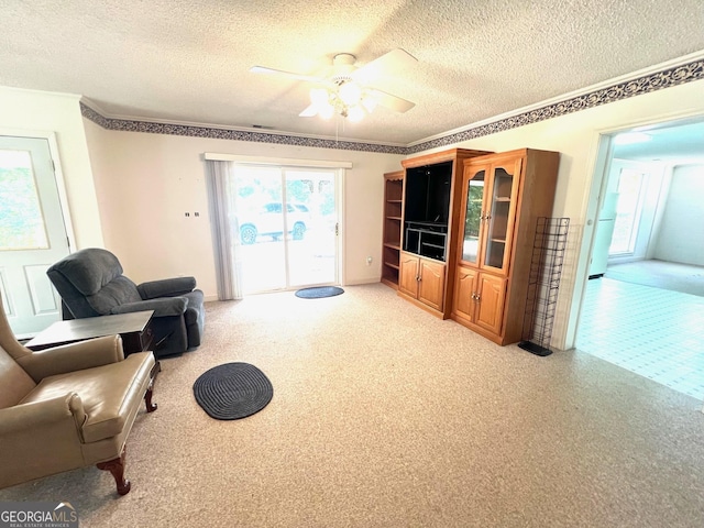 interior space featuring ceiling fan, light colored carpet, and a textured ceiling