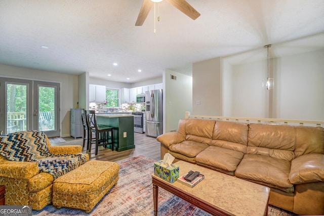 living room featuring ceiling fan and light hardwood / wood-style floors