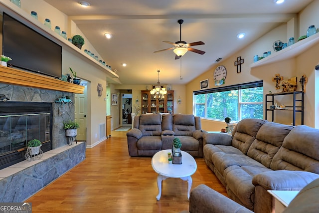 living room featuring high vaulted ceiling, ceiling fan with notable chandelier, a fireplace, and light hardwood / wood-style flooring