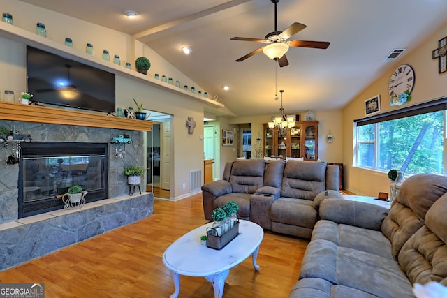 living room featuring ceiling fan with notable chandelier, hardwood / wood-style floors, high vaulted ceiling, and a fireplace