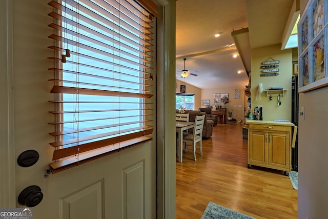 doorway featuring lofted ceiling, light hardwood / wood-style flooring, and ceiling fan