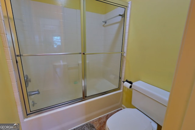 bathroom with shower / bath combination with glass door and toilet