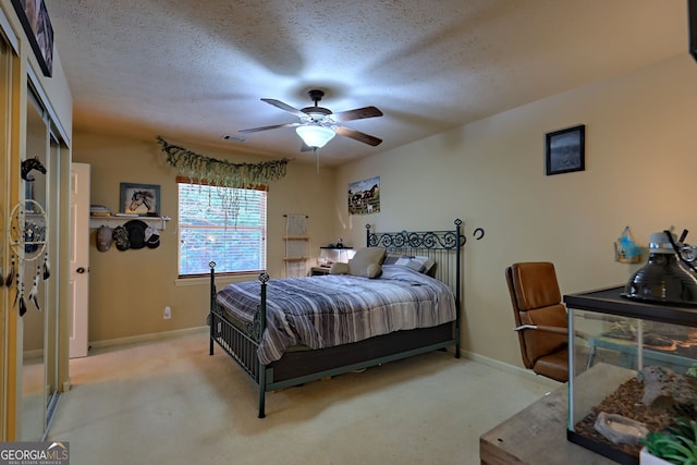 bedroom with a textured ceiling, ceiling fan, a closet, and carpet floors