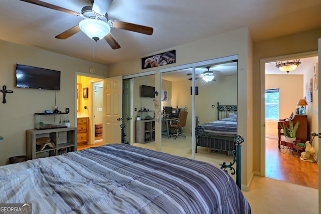 bedroom featuring ceiling fan, hardwood / wood-style floors, and two closets