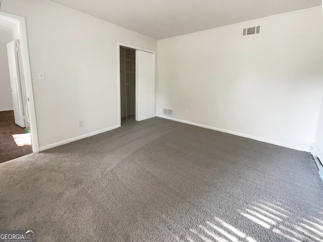 unfurnished bedroom featuring a closet and dark colored carpet