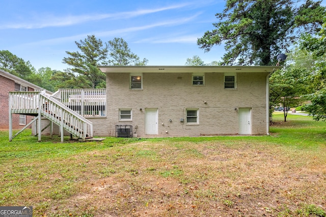 back of property with central air condition unit, a yard, and a deck